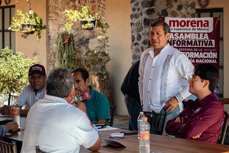 Arturo Solano escucha a vecinos reunidos en una mesa.